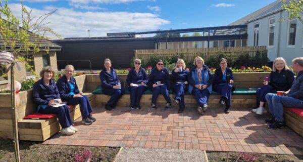 A group of medical staff having tea in an outdoor space